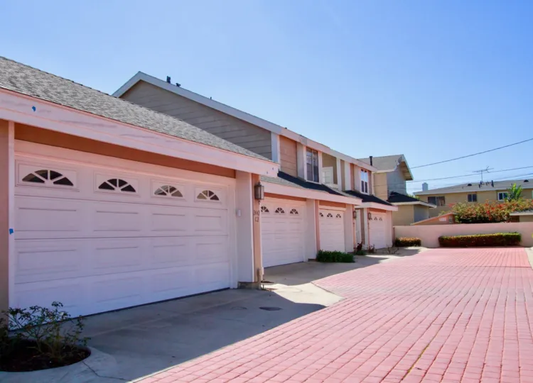 Pink cobblestone, steeple-roofed homes, mark pleasant view of residential area, on summer day, Spinnaker Cove, Costa Mesa, California