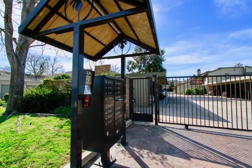 THE FRONT GATE IS LOCATED FIRST AND THEN A HOUSE IS AVAILABLE AT LITTLE LONG FROM THE GATE AND SOME TREES ALSO THERE.