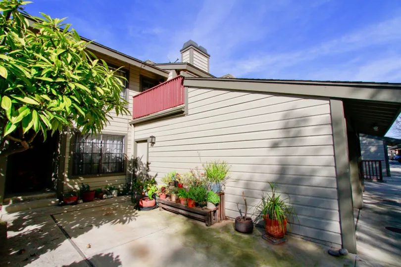 Sunset BluffsCosta Mesa California building side way door near tree and grass pot gray paint