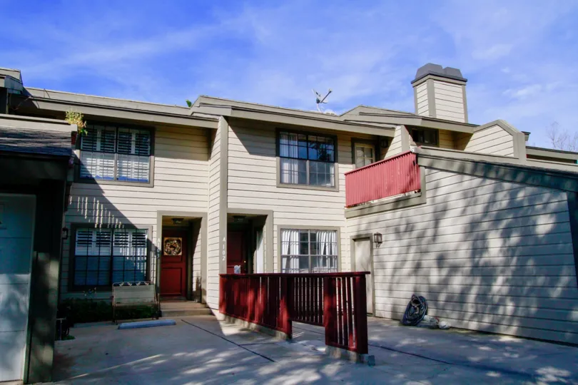 Tan exterior multi level duplex with deck and garage