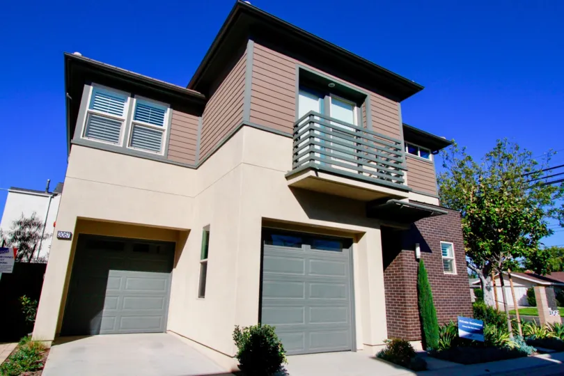 Two story The Edge apartment with a garage and balcony on a sunny day.