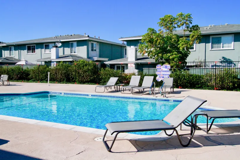 Nice blue coloured swimming pool with chairs between villas in The Vendome of Costa Mesa