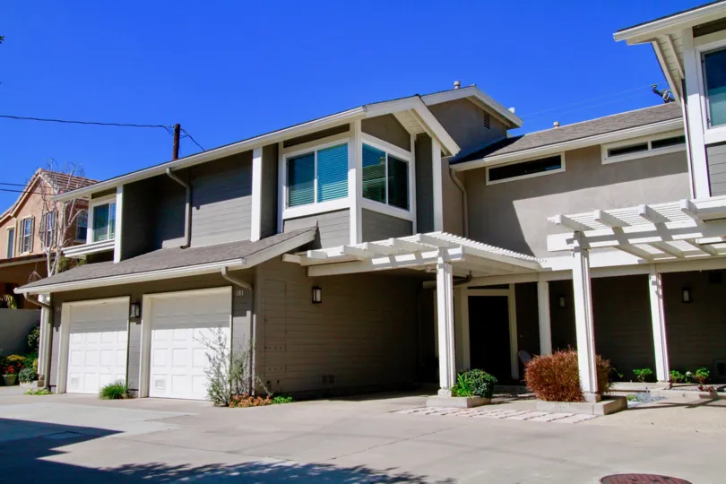 The Village at Admiral Way gray two story homes with garages and columns on a sunny day.
