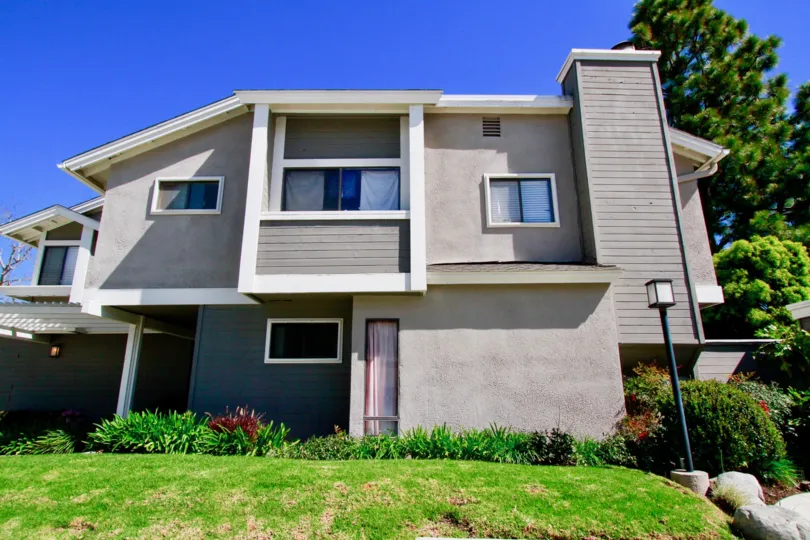 The Village at Admiral Way Costa Mesa California bulding color light gray near to garden grass light post back side big tree cooling air come to very super