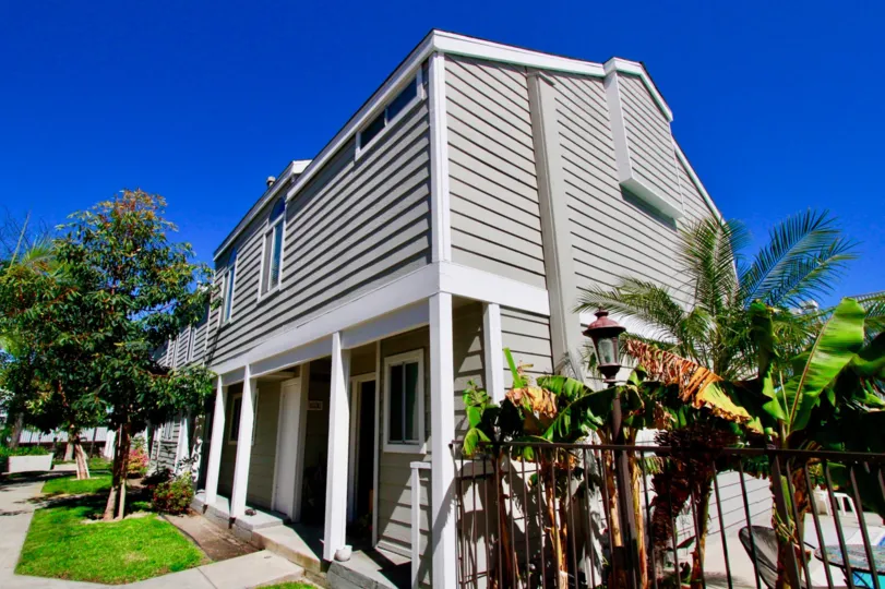 A two story condo home with gray wooden palens locatedi n Costa Mesa in Victoria Garden Villas