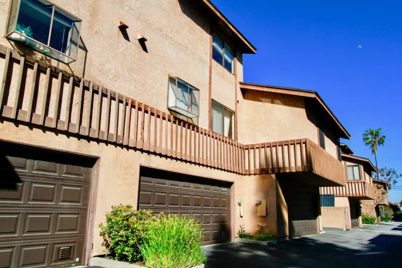 Three large brown garage doors attached to the base of town homes in Villa Maple in Costa Mesa CA
