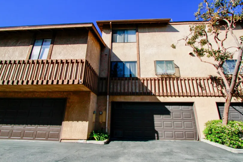 the brown garage doors along the street of the Villa Maple community