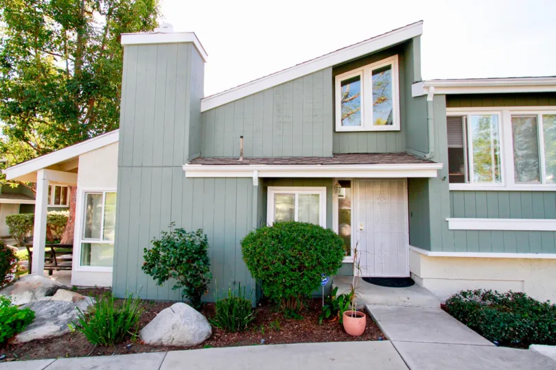 a trendy grey modern house which has the garden in front of that is located in village creek of costa mesa, california