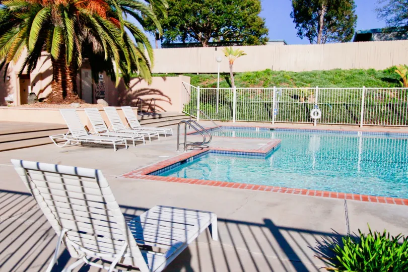 Fabulous swimming pool with chairs and trees around near villas in Westbluff Village of Costa Mesa