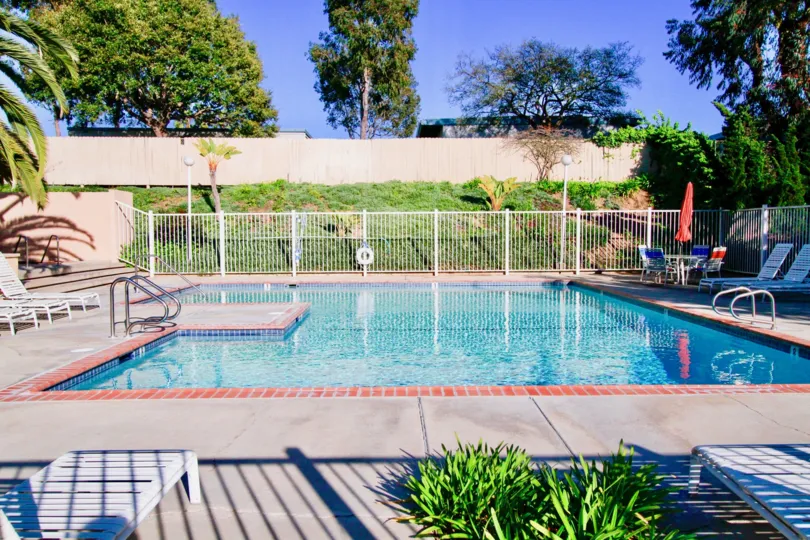 THE LONG GATE AVAILABLE AT THE BACK OF THE SWIMMING POOL AND SOME SITTING CHAIRS ALSO LOCATED AT THE SIDE OF THE POOL SOME TREES ALSO AVAILABLE.