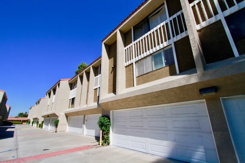 The big apartments in the Wilson Park Condos with big doors and ornamental plants near the road side.