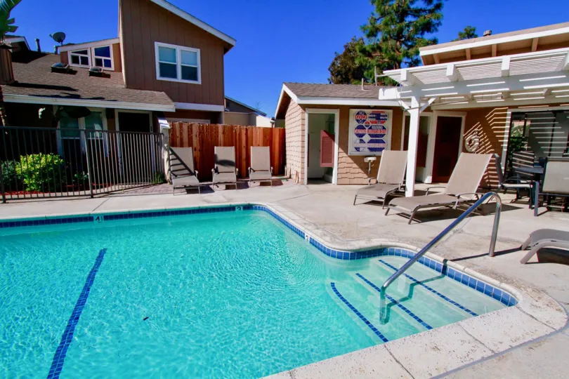 Woodstream Condos Costa Mesa California bulding near to one big size swming pool and steps water blue color very nice home near two wood bad attached daily take the sun both very use