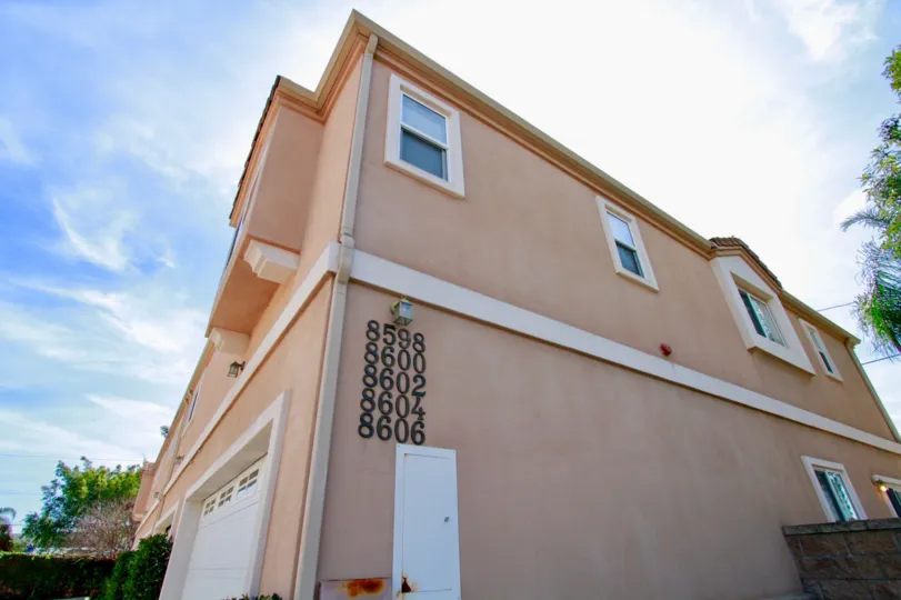The side view of a stucco building in the Belmont Grace community on a sunny day