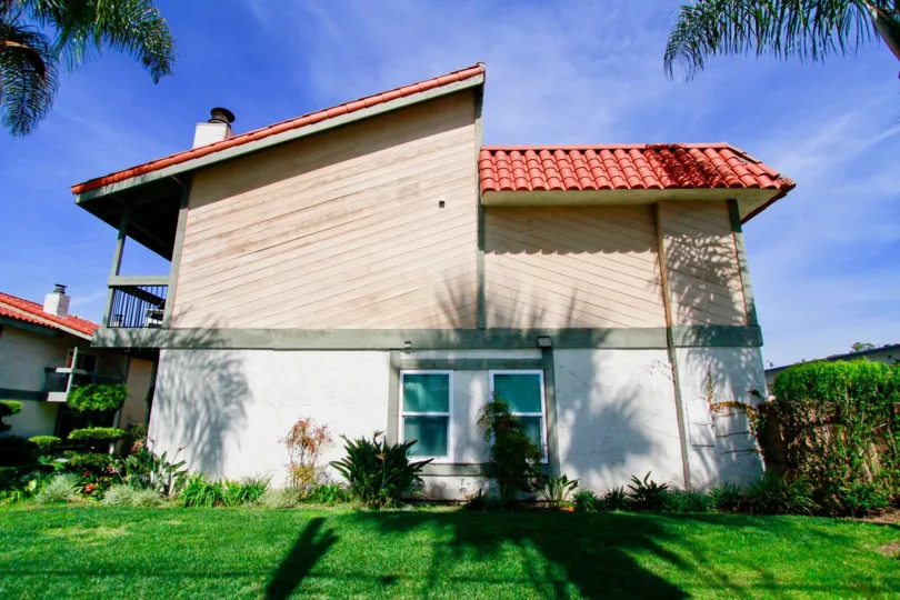 A BUNGALOW WITH A ROOF TOP AND IT LOOKS LIKE RED COLOR AND SOME PLANTS ALSO NEAR TO THE HOUSE AT THE MORNING SUNSHINE TIME
