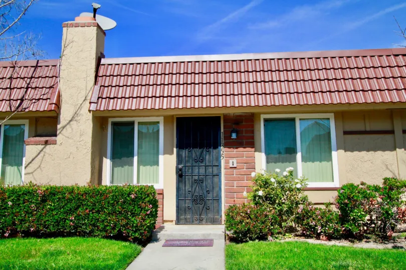 The entrance to a home in Cypress Village on a sunny day showing the landscaping