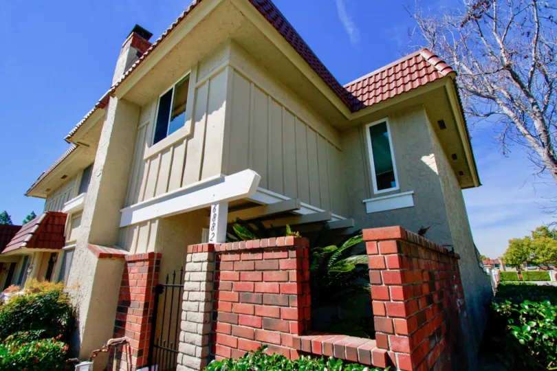 A sunny day at the front gate of a two-floor house in the Cypress Village community