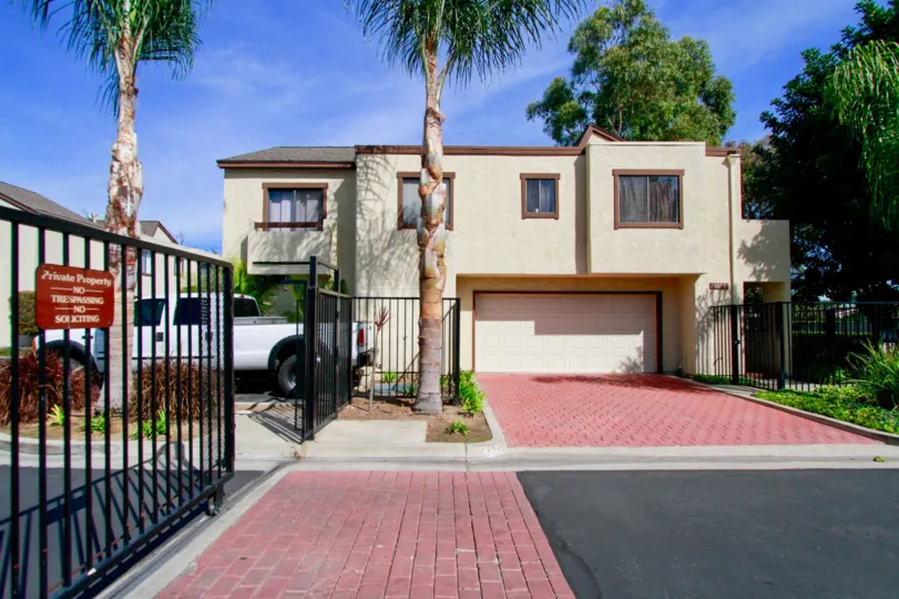 A street view and landscaping outside a stucco building in Embassy Park Townhomes