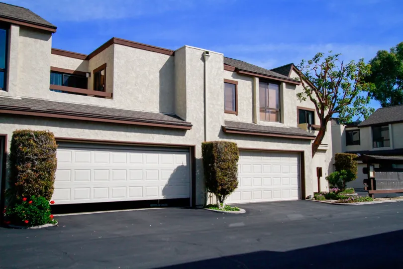 Small condos with large garages surrounded by nice trees.