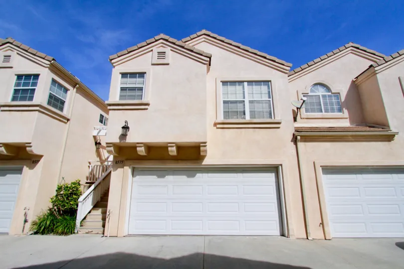 A garage and front view of a unit at Moody Townhomes on a sunny day