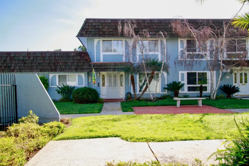 THE HOUSE WITH BLUE COLOR PLACE AND THE GRASS ALSO LOCATED AT THE PLACE AND TREES ALSO NEAR TO THERE AT THE MORNING TIME