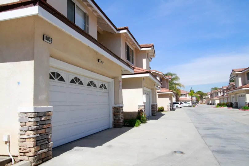 A sunny day in the Villa Woods community with some cars parked at the front garage of some houses.