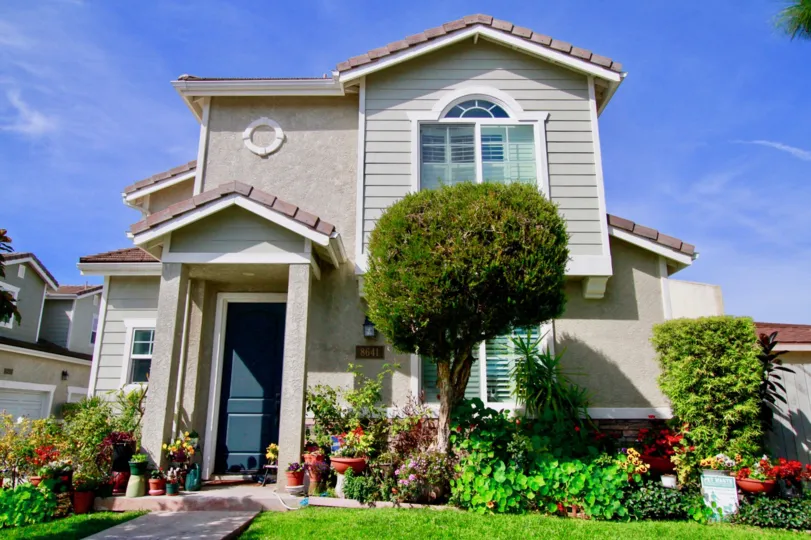 A sunny day at the front yard of a house with trees and a bunch of nice bushes in the Willow Tree Estates neighborhood