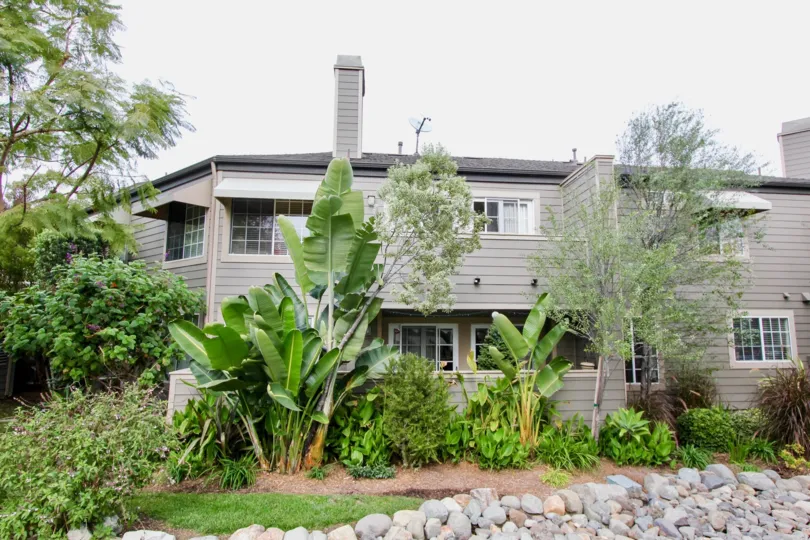 A cloudy day in the Bluffside Villas with some plants in front of a house.