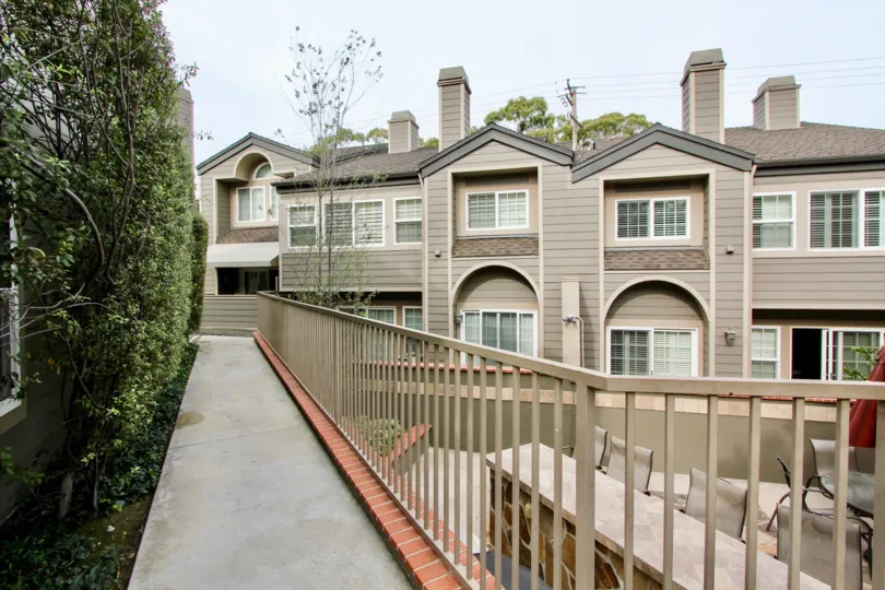 a pleasant day in the bluffside villas with a building that has lenghty passage and dinning tables on the right outside