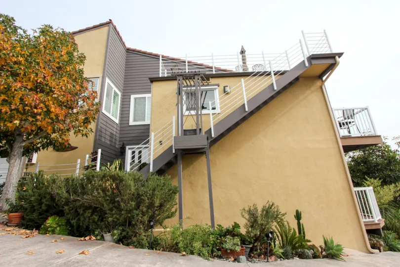 Front of the Stairs has trees with different color leaves and has flower pots