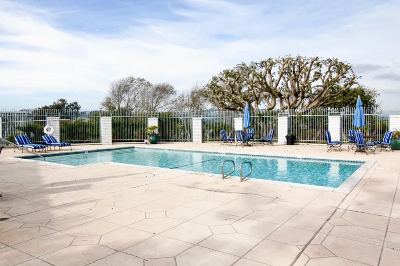 a sunny day in the dana bluffs with a swiming pool that has clear blue water andsteel compound around
