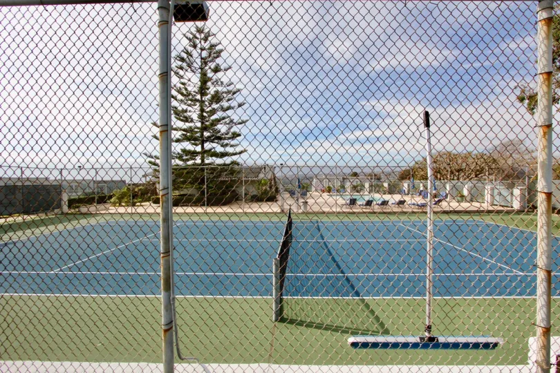 A sunny day in the Dana Bluffs with a blue color tennis court.