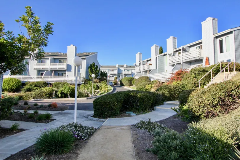 Pathway between the Apartments in Dana Vista has bushes and plants with light lamps in certain distances