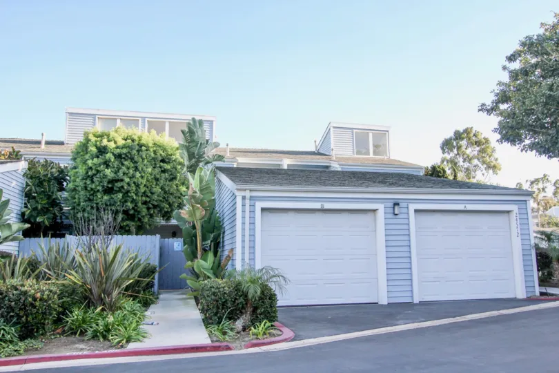 a sunny day in the dana vista with a house that has small wooden door and compound wall