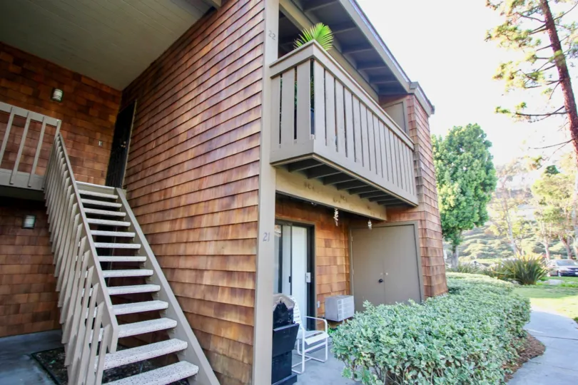 Villa in Harbor Creek has dense bushes in front of the door with chairs and dustbin