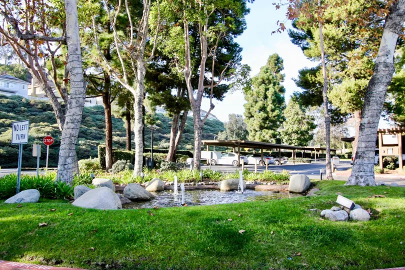 THE MOUNTAIN PLACE IN THE HARBOR CREEK WITH THE CAR PARKING, NO LEFT TURN BOAR, LAWN, PLANTS, TREES