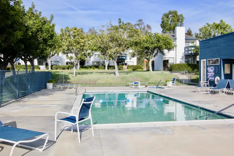 a sunny day in the marbella racquet club with a swimming pool that has steel compound and resting table around