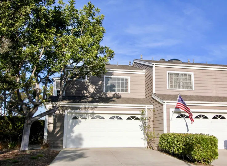 A bright day in the Marinita Townhomes with a building and flag.