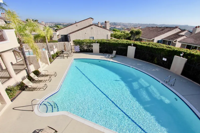 THE TOP VIEW OF THE BUILDINGS IN THE MONARCH BAY VILLAS WITH THE SWIMMING POOL, TABLES, PLANTS