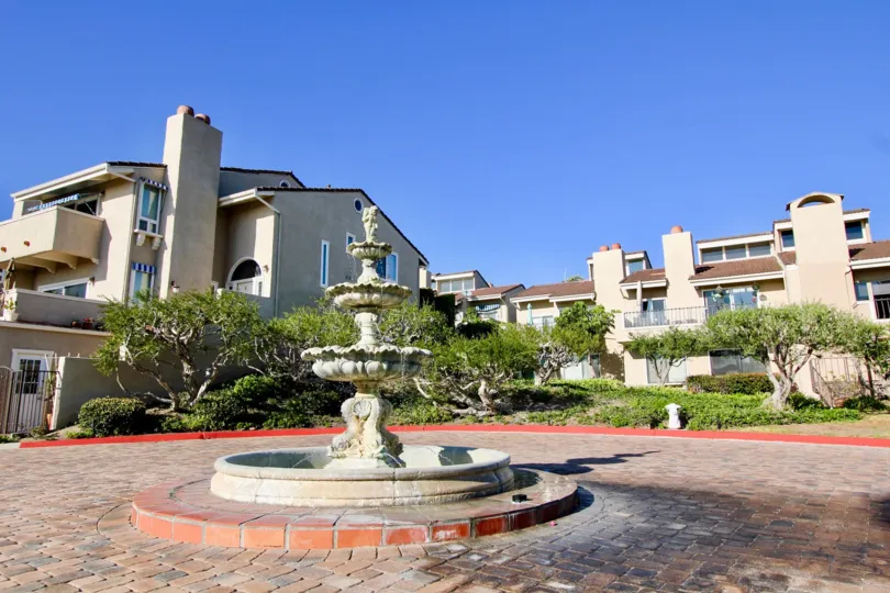 A beautiful day in the Monarch Bay Villas with a water fountain and plants.