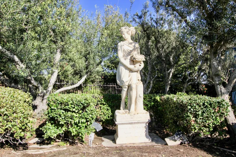 A sunny day in the Monarch Bay Villas with a sculpture and trees.