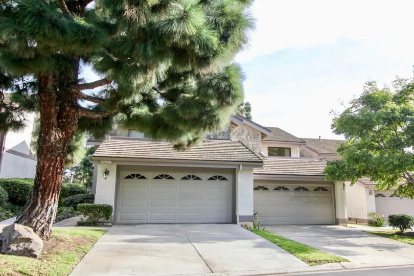 Front garage doors and open space with trees of Old Mill Pond community, Dana Point, CA