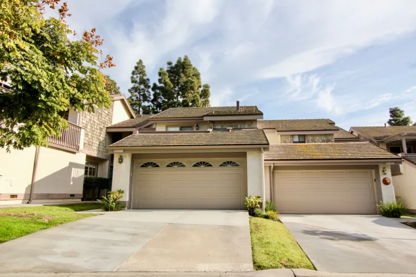 THIS PICTURE SHOWS THAT THE BUILDINGS WITH THE SHUTTERS, PLANTS, TREES, LAWN