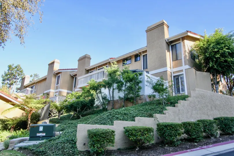 Side view with plants, trees and walkway in Pacific Island Villas community, Dana Point, CA