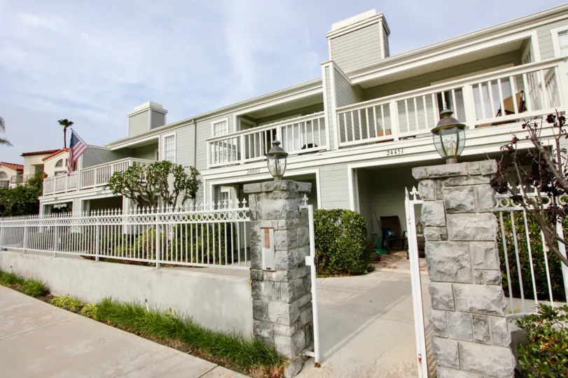 a sunny day in the pilgrims bluff with house that has stone walls and storey in flag