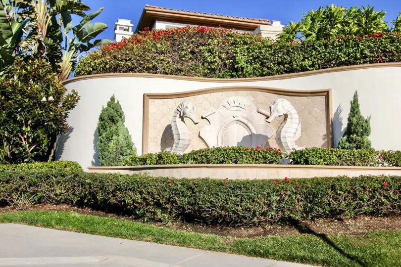 A sunny day in the Pointe Monarch with a sculpture and garden.