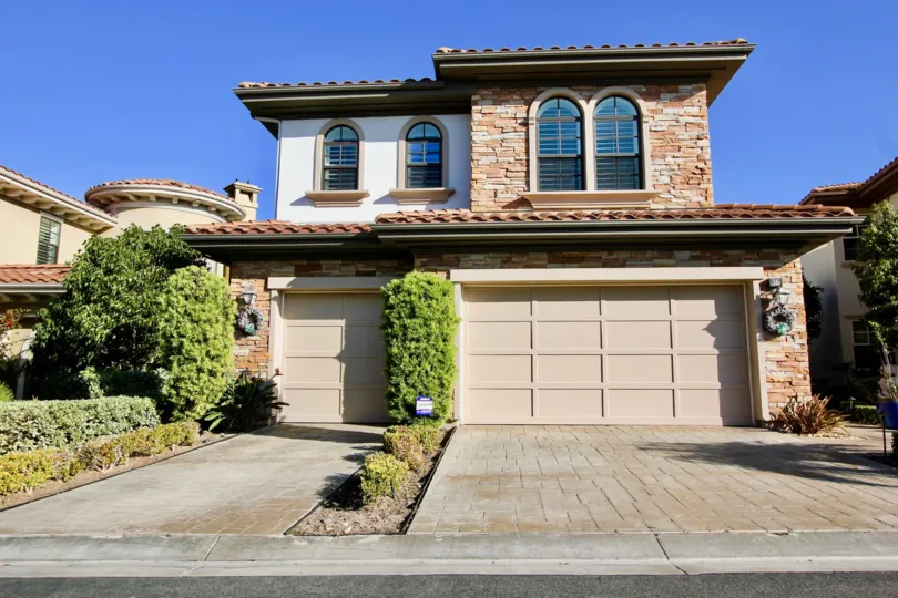 a sunny day in the pointe monarch with house that has stone walls and 2 doors