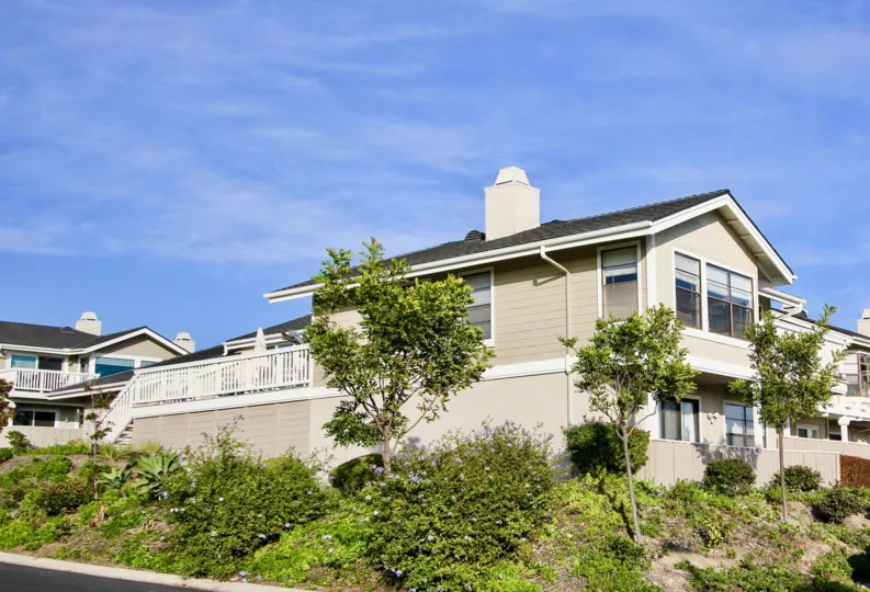 a sunny day in the sea ridge with house that has glass winow and garden around