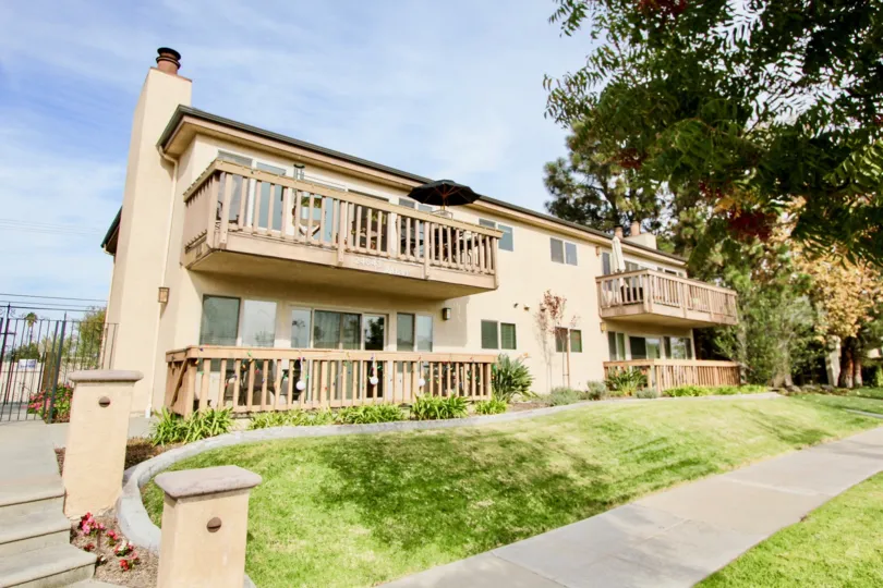 a pleasant day in the spindrifter condos with a building that has umberlla on the first floor and garden in front