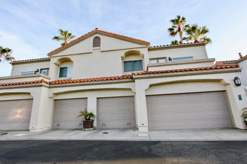 A sunny day in the Tennis Villas with a building and plant.