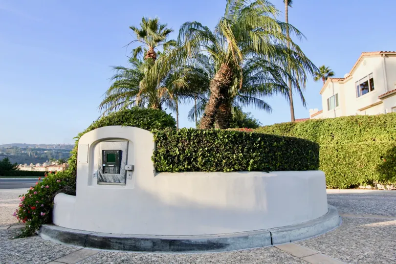 A round cement island with an intercom on it's side at Tennis Villas in Dana Point CA